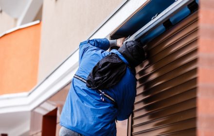 Man installing roller shutter on window Man installing roller shutter on window